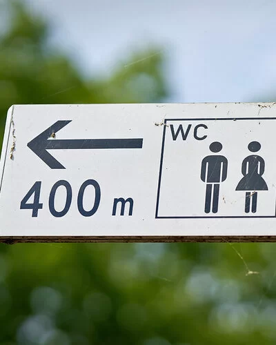 Ein Wegweiser zeigt den Weg zu einer öffentlichen Toilette, die 400 Meter entfernt ist.