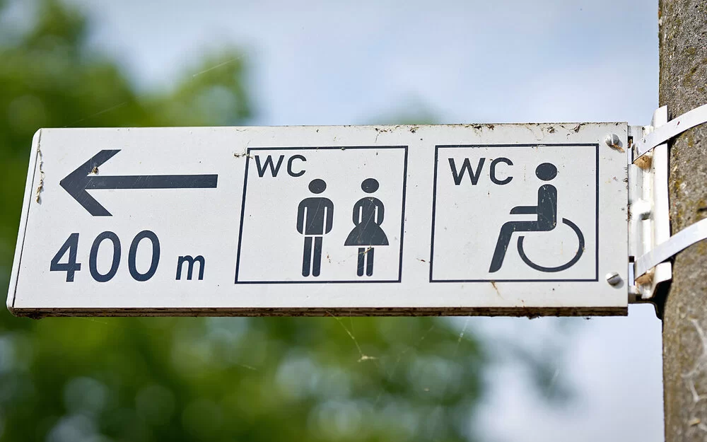 Ein Wegweiser zeigt den Weg zu einer öffentlichen Toilette, die 400 Meter entfernt ist.