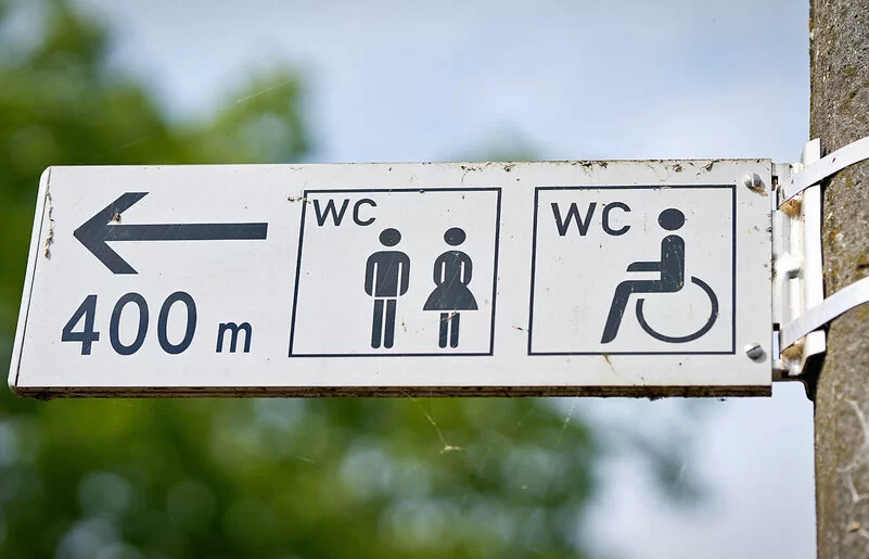 Ein Wegweiser zeigt den Weg zu einer öffentlichen Toilette, die 400 Meter entfernt ist.