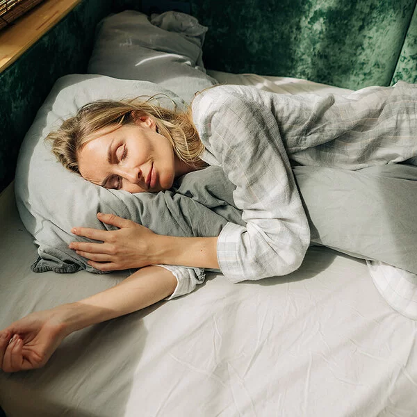 Warum träumen wir? Eine Frau liegt in ihrem Bett und schläft.