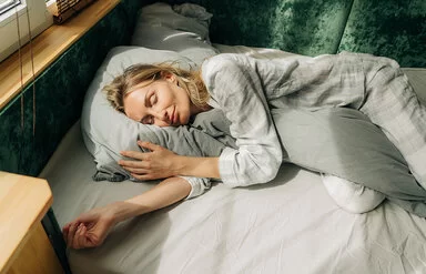 Warum träumen wir? Eine Frau liegt in ihrem Bett und schläft.