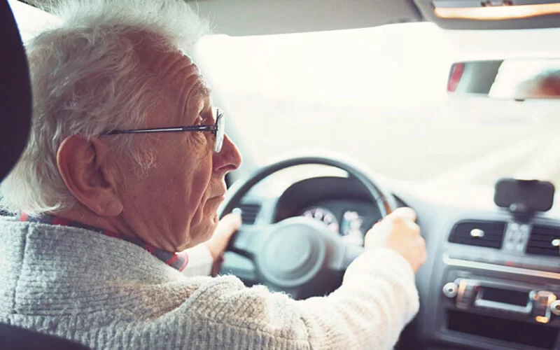 Älterer Mann am Autosteuer leidet unter grünem Star.