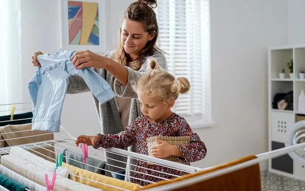 Mutter leistet Care-Arbeit und kümmert sich gleichzeitig um Haushalt und Erziehung ihrer Tochter.