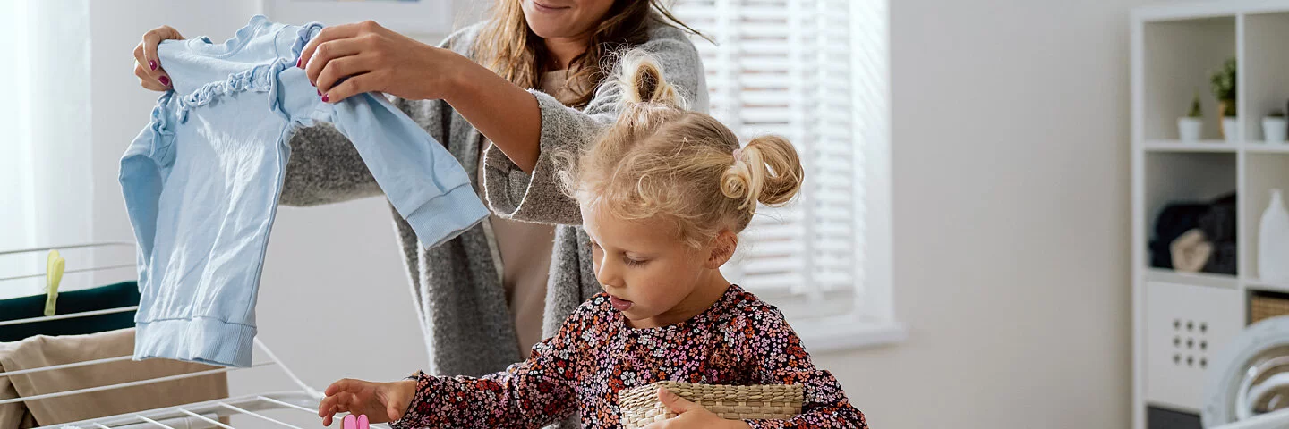 Mutter leistet Care-Arbeit und kümmert sich gleichzeitig um Haushalt und Erziehung ihrer Tochter.