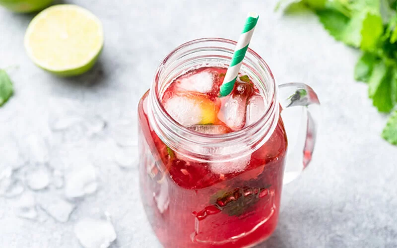 Auf dem Tisch steht ein roter Beeren-Eistee.