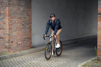 Ein Mann fährt auf einem Fahrrad und verlässt die Hofausfahrt.