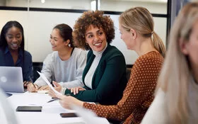 Eine Gruppe von Geschäftsfrauen, die wertschätzend kommunizieren und zusammenarbeiten.