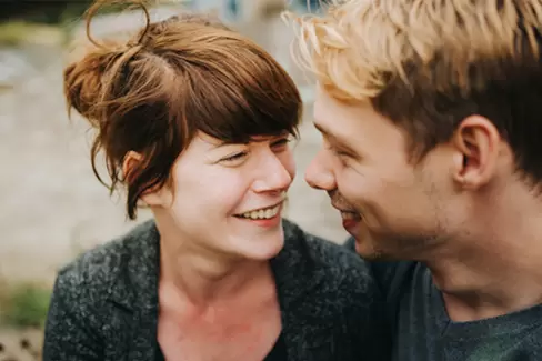 Eine junge Frau und ein junger Mann schauen sich lächelnd an