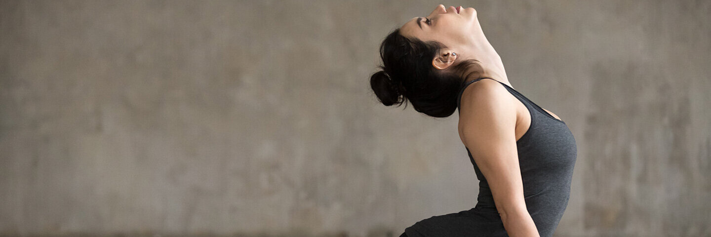 Eine Frau macht auf einer Matte eine Yoga-Übung