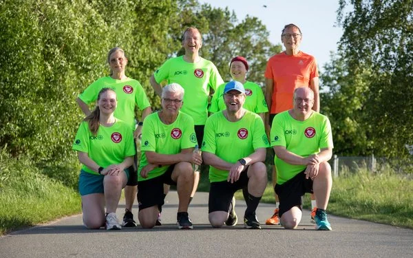 Gruppenbild von acht Läuferinnen und Läufern im Grünen.