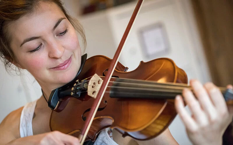 Eine junge Frau übt Geige.