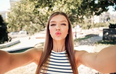 Ein Mädchen formt bei einem Selfie mit den Lippen einen Kussmund.