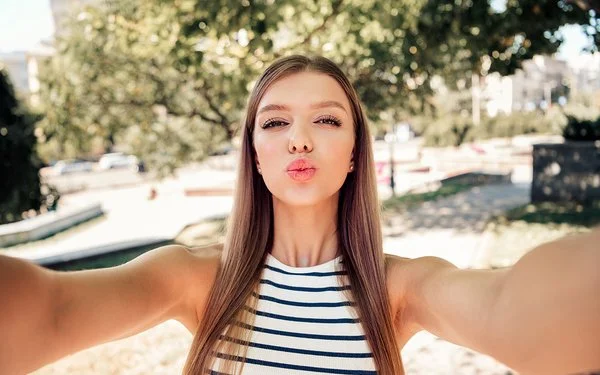 Ein Mädchen formt bei einem Selfie mit den Lippen einen Kussmund.