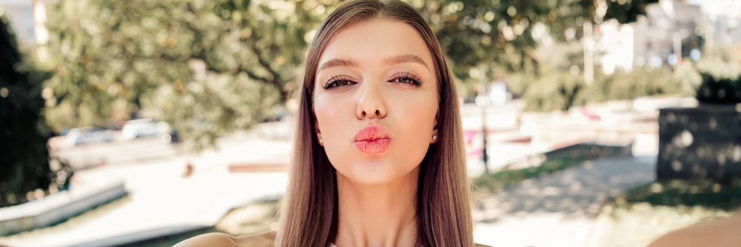 Ein Mädchen formt bei einem Selfie mit den Lippen einen Kussmund.