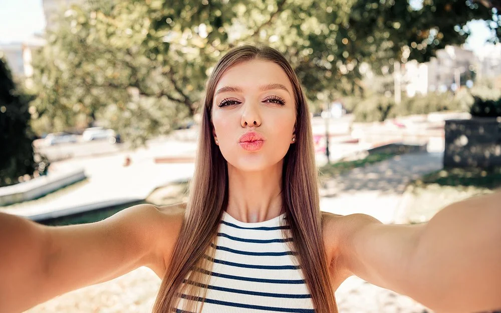 Ein Mädchen formt bei einem Selfie mit den Lippen einen Kussmund.