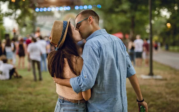 Ein junges Pärchen küsst sich auf einem Musikfestival.