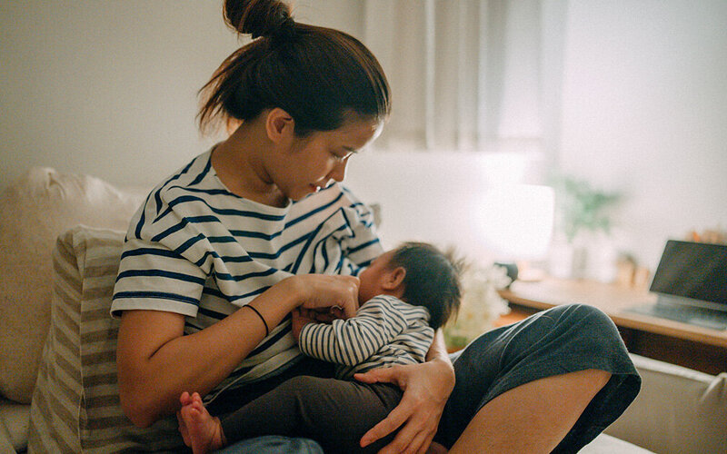 Eine Frau stillt ihr Baby.
