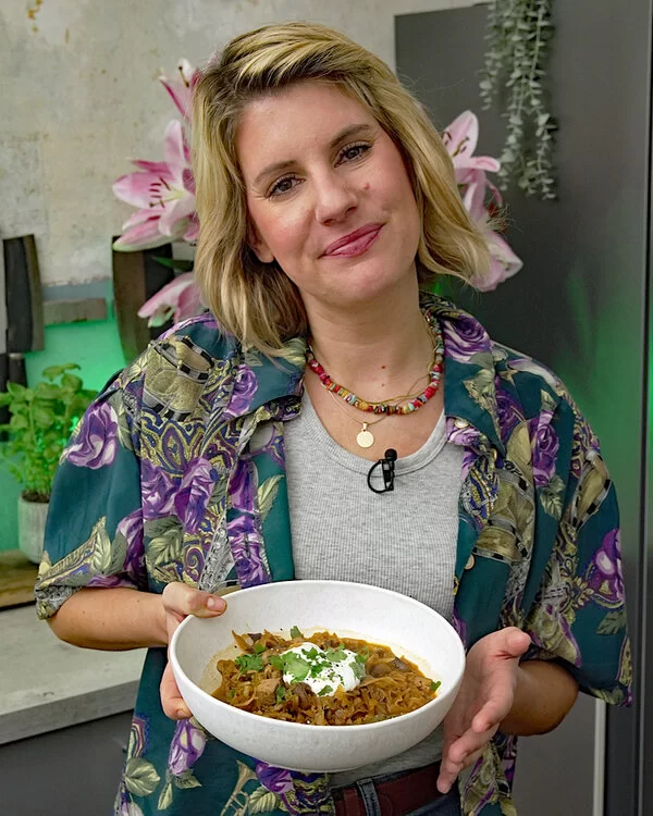 Felicitas Then hält einen Suppenteller mit vegetarischem Bigos in die Kamera.