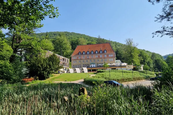 Das Sonnenresort Ettershaus in Bad Harzburg steht bei sonnigem Wetter auf einem Hügel.