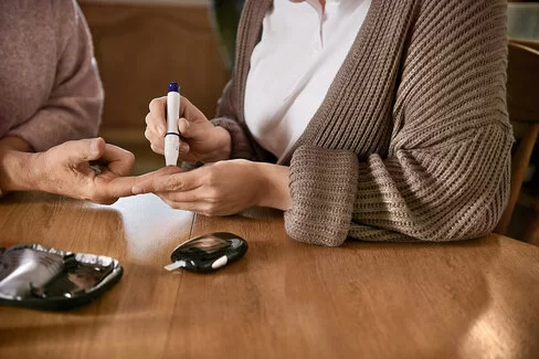 Zur Blutzuckermessung wird ein Tropfen Blut aus dem Finger entnommen. Blutzuckermessgeräte unterstützen Diabetes-Patienten.