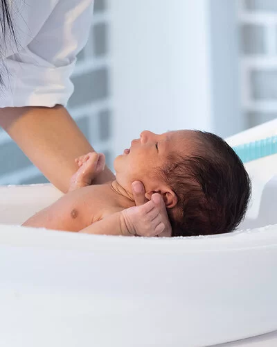 Ein Baby wird in einer Babybadewanne gebadet.