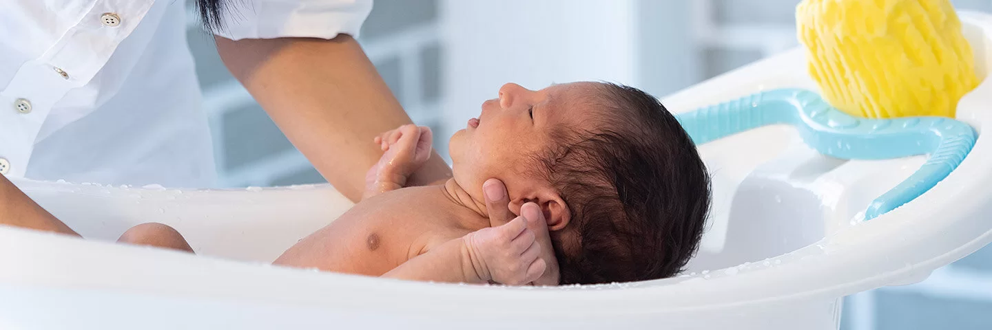 Ein Baby wird in einer Babybadewanne gebadet.