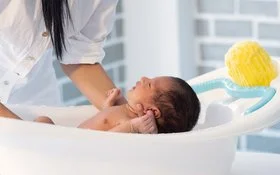 Ein Baby wird in einer Babybadewanne gebadet.