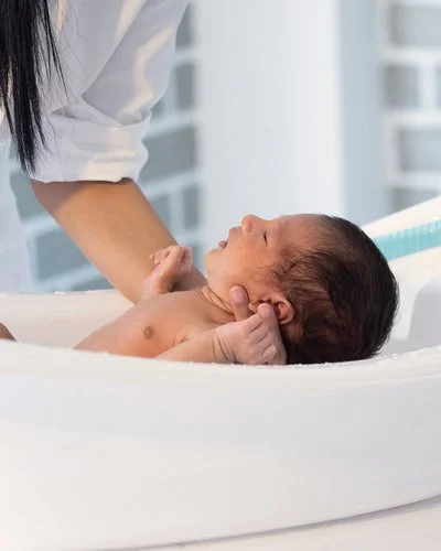 Ein Baby wird in einer Babybadewanne gebadet.