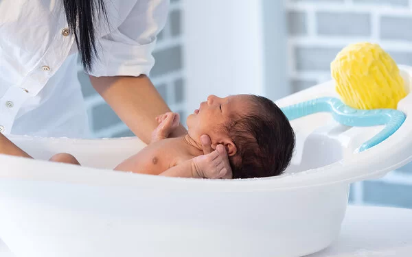 Ein Baby wird in einer Babybadewanne gebadet.