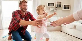 Vater und Mutter bringen ihrem Baby spielend das Laufen bei, es ist eine wichtige Phase in der Entwicklung eines Babys.