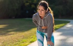 Junge Frau plagt Übelkeit nach dem Sport.