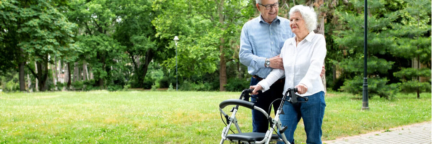 Eine Frau nutzt als Unterstützung beim Gehen einen Rollator. Gehhilfen erleichtern den Alltag von Patienten.