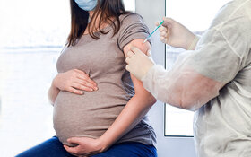 Arzt impft schwangere Frau.