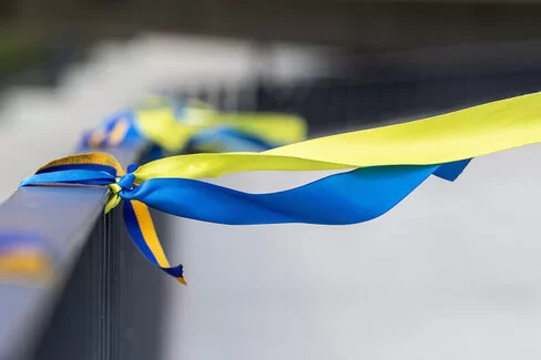 Bänder in den Farben der Nationalflagge der Ukraine sind an ein Geländer einer Brücke gebunden.