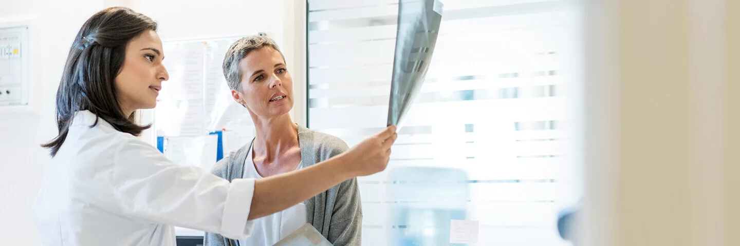 Eine Ärztin erklärt ihrer Patientin anhand von Röntgenbildern den aktuellen Befund. Gemeinsam besprechen sie das weitere Vorgehen.