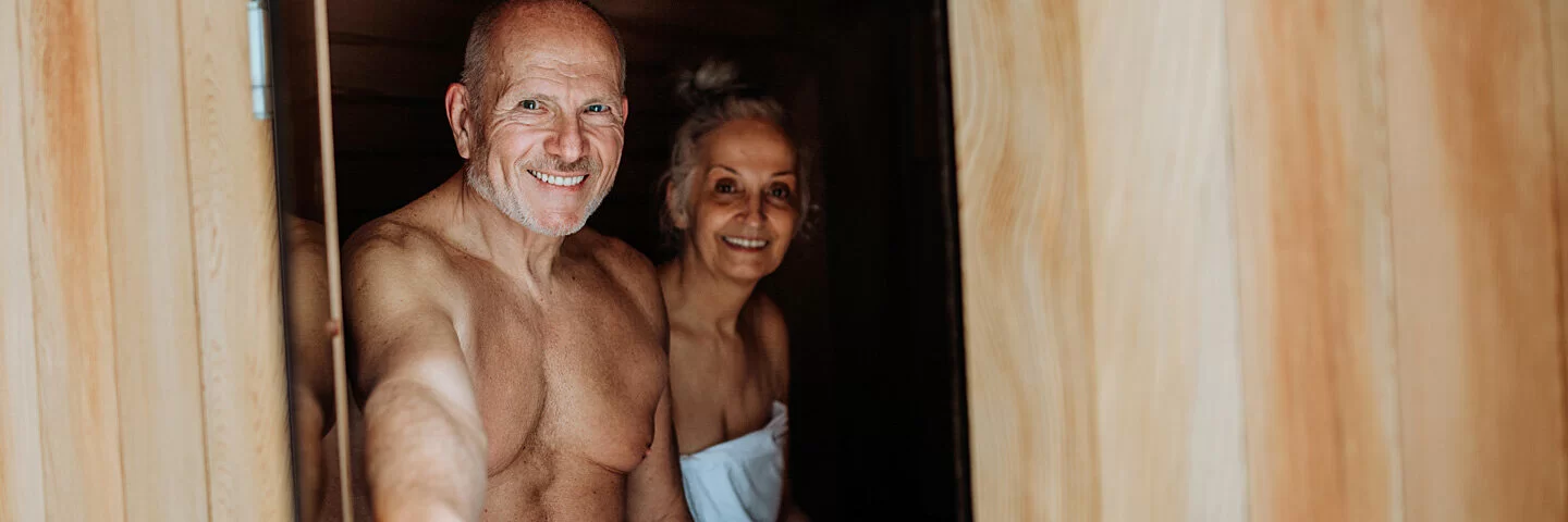 Ein Mann und eine Frau sitzen in einer Sauna.