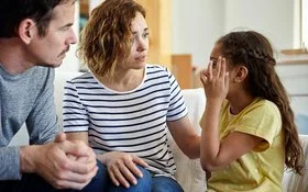 Eltern hören ihrem Kind zu, das von Kopfschmerzen und Migräne berichtet.