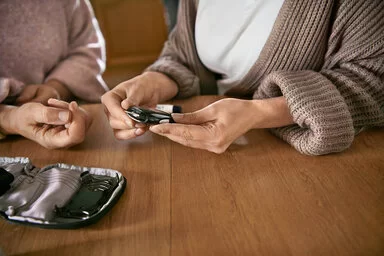 Ein Patient oder eine Patientin mit Diabetes bestimmt den Blutzucker. Der AOK-Curaplan Diabetes hilft, Krankheitsfolgen zu vermeiden.