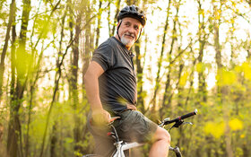 Ein älterer Mann mit Diabetes fährt Fahrrad.