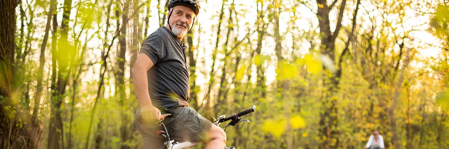 Ein älterer Mann mit Diabetes fährt Fahrrad.