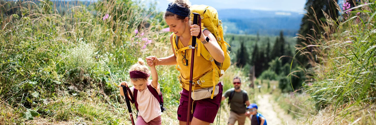 Eine Mutter und ein Vater sind beim Erlebniswandern mit ihren Kindern zu sehen.