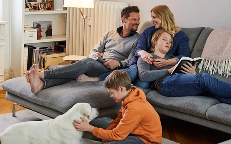 Familie Seidel sitzt gemeinsam auf der Couch. 