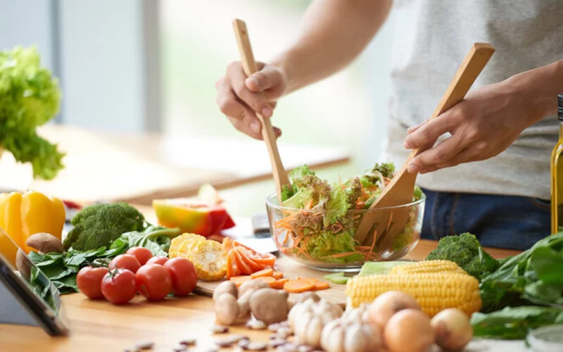 Eine Person macht sich einen Salat und schont so das Klima.