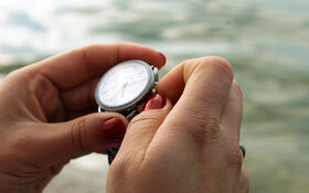 Frau stellt ihre Armbanduhr um, denn es ist Zeitumstellung.