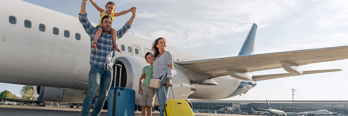 Familie mit Kinder stehen vor einem Flugzeug und warten darauf, gemeinsam zu verreisen.