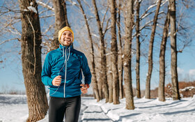 Ein Mann geht im Winter und Schnee joggen.