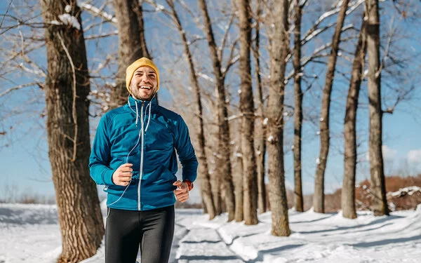 Ein Mann geht im Winter und Schnee joggen.