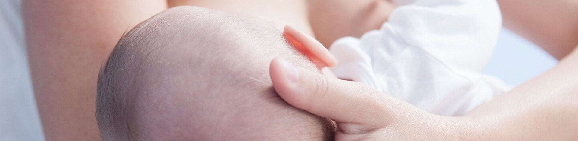 Eine Mutter hält ihr Baby im Arm und stillt es.