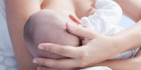 Eine Mutter hält ihr Baby im Arm und stillt es.