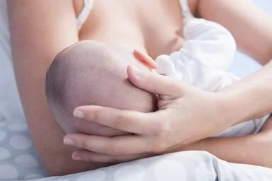 Eine Mutter hält ihr Baby im Arm und stillt es. 